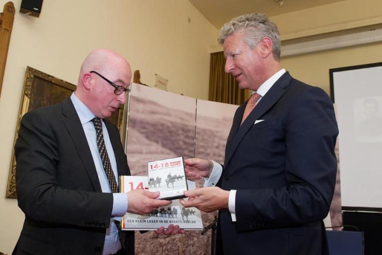 Verteidigungsminister Pieter De Crem überreicht dem Bürgermeister von Dendermonde, Piet Buyse, ein Exemplar des Buches und des Filmes „Eine kleine Armee im Großen Krieg".